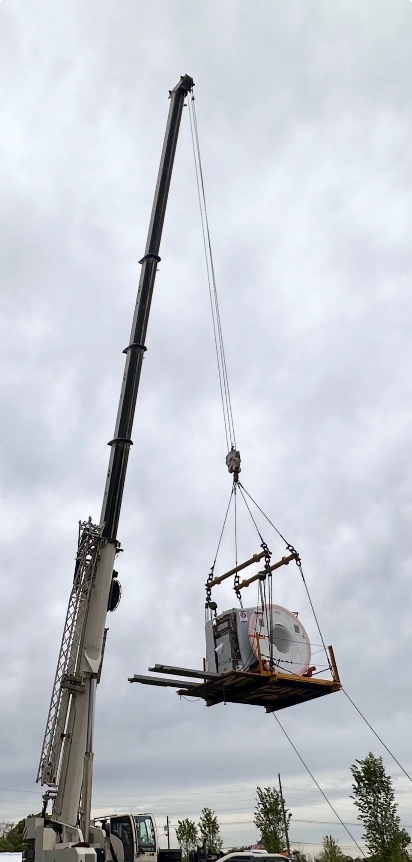 An 80-ton crane hoisting a new MRI machine during a medical equipment replacement project